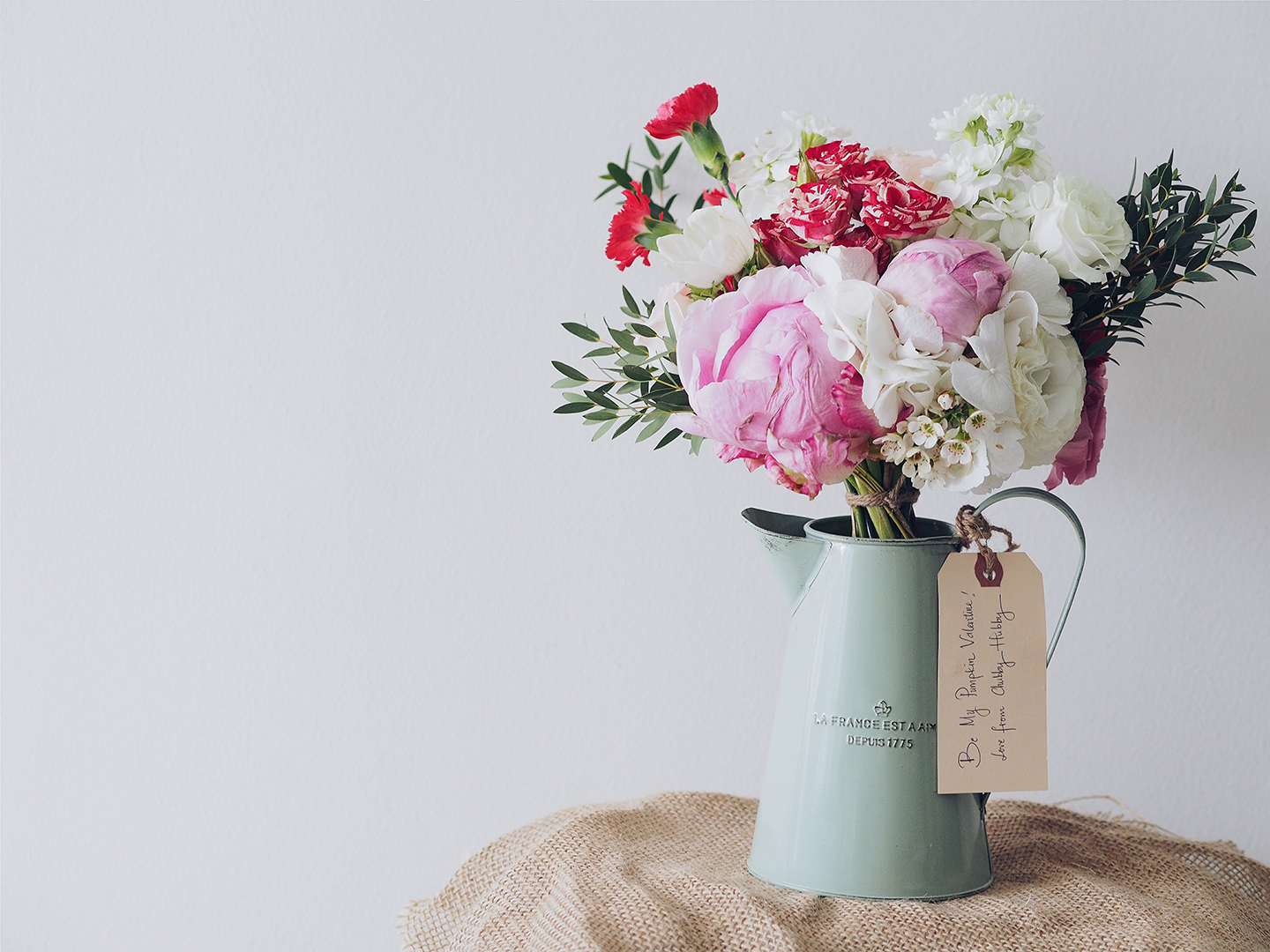 Un bouquet de pivoines et de roses blanches offert en cadeau pour la Saint-Valentin.