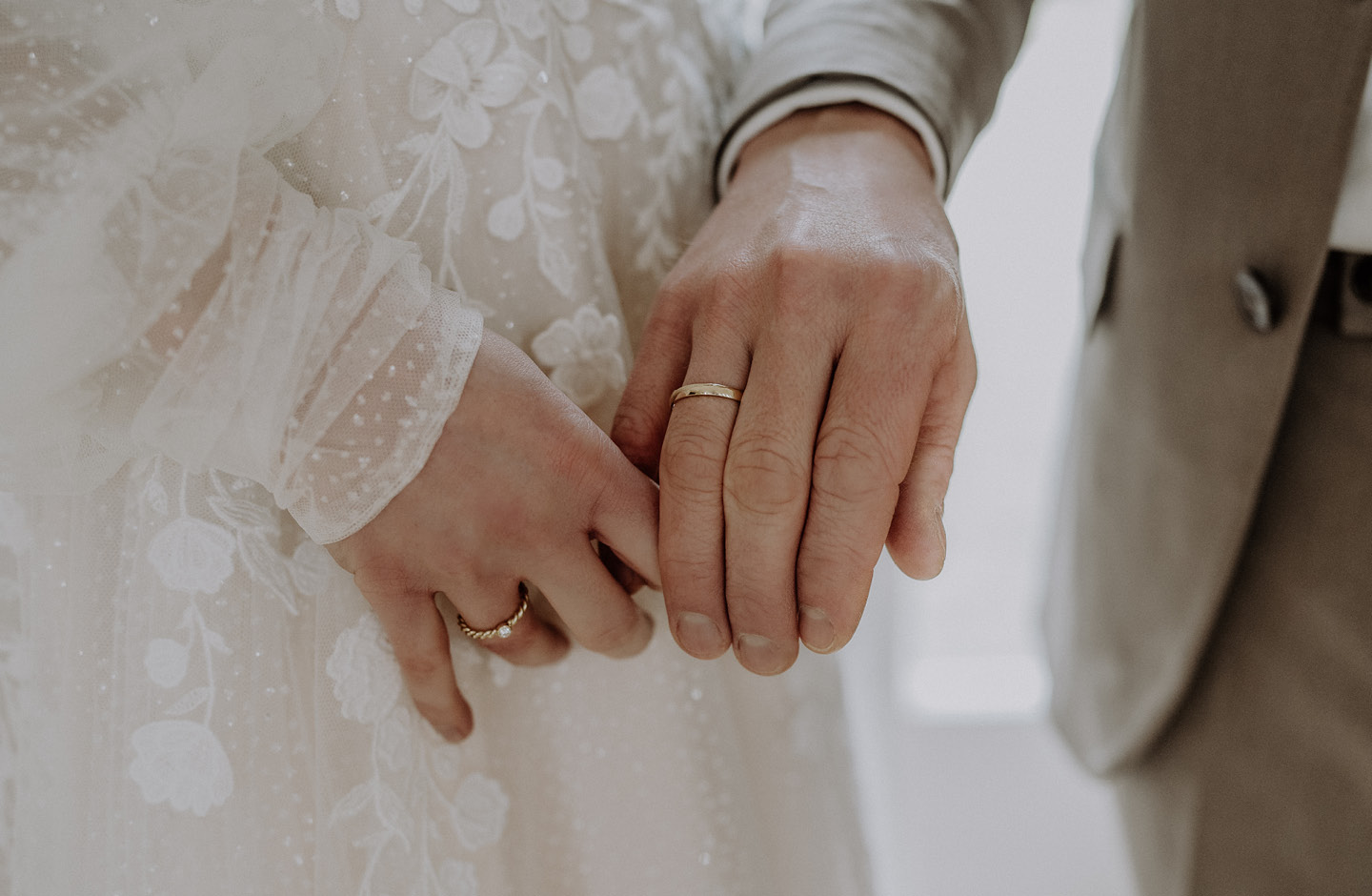 Les mains d'un couple marié tenant des bagues de mariage.